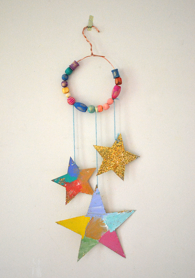 Kids make glittery star mobiles with cardboard, wire, and painted wooden beads.