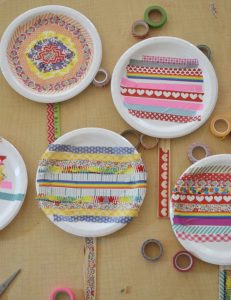 Kids use washi tape to decorate paper plates and make lollipops.