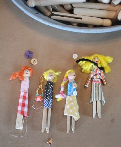 Kids make little people from clothespins and fabric scraps.
