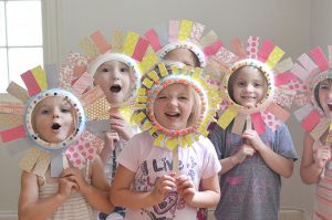 Kids make flower faces from paper plates.