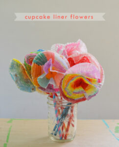 Kids make flower bouquets from cupcake liners and straws.