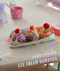 Kids make ice cream sundaes from paper mache.