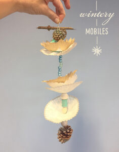 Kids make wintery mobiles with pinecones and cupcake liners.
