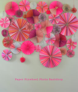 Make a photo backdrop wall with paper pinwheels, big and small.
