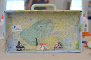 Kids use their imaginations to create adventure boxes with maps and a materials table. A wonderful creative invitation.