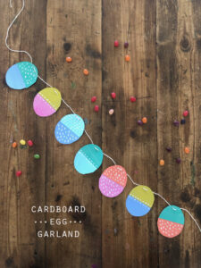 Make a simple egg garland with painted cereal box cardboard.