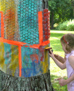 Wrap a tree with recycled babble wrap, give kids rollers and paint, and let them make prints!