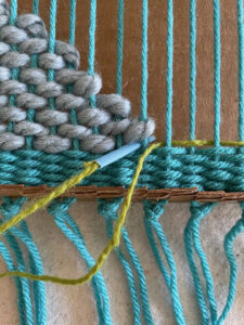 Doodle weaving on a cardboard loom with colorful yarns
