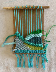 Doodle weaving on a cardboard loom with colorful yarns