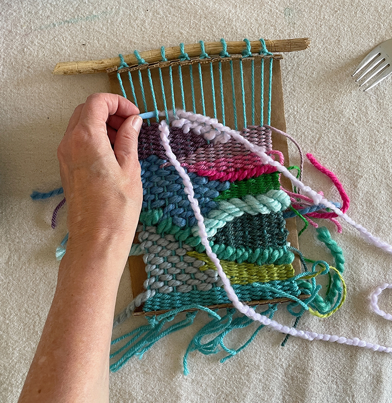 Doodle weaving with a cardboard loom and colorful yarns