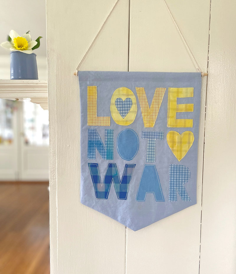 DIY "Love not War" banner for Ukraine, made from old shirts.