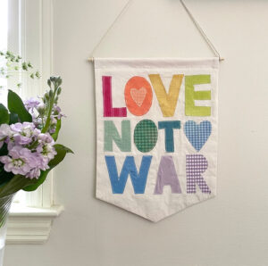 DIY "Love not War" banner, made from old shirts.