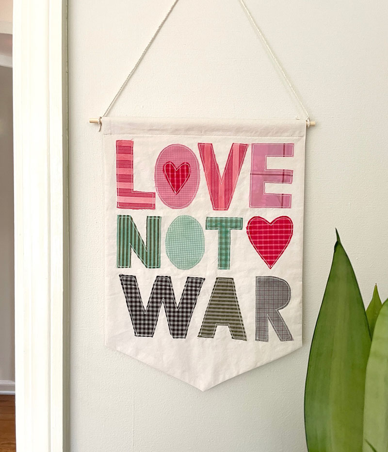 DIY "Love not War" banner, made from old shirts.