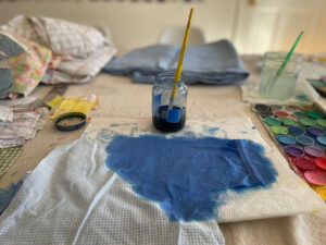 Painting old fabric shirts to make "Love not War" banners.