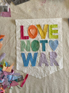 DIY "Love not War" banner made from old shirts.