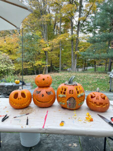 Carved pumpkins, included the pumpkin cottage, on a table