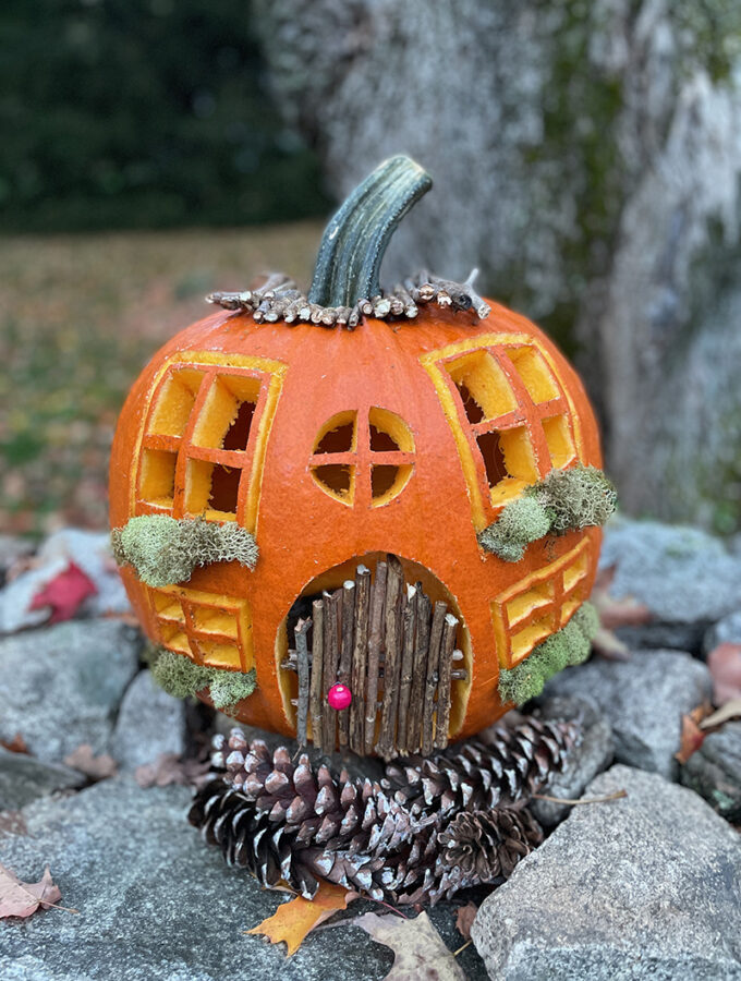 Carve a pumpkin to look like a charming cottage, with a twig door and moss window boxes.