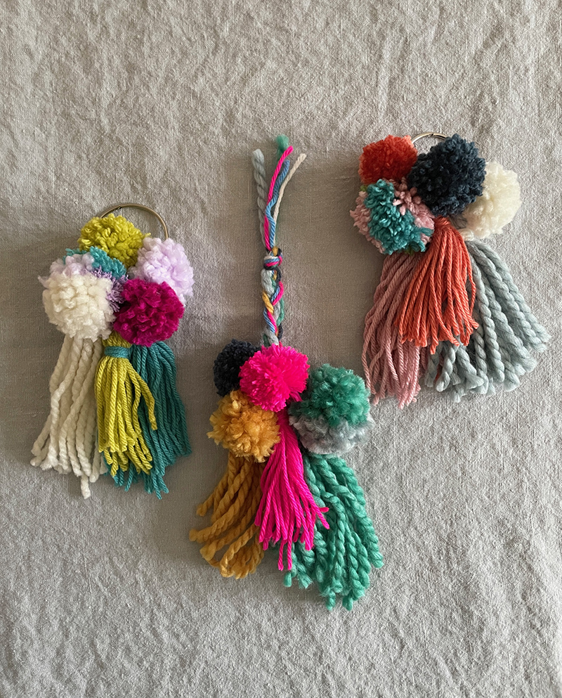 Pom-poms and tassels made with yarn and tied to a book ring