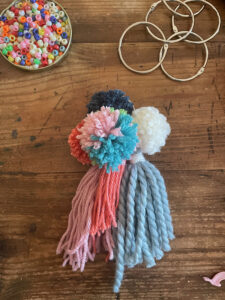 Finished pom-pom tassel with book rings and beads on a table