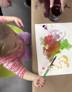Young toddler exploring paint for the first time.