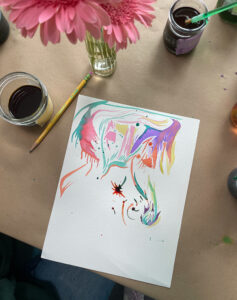 Painting by teen, playing around with liquid watercolor at the flower still-life table.