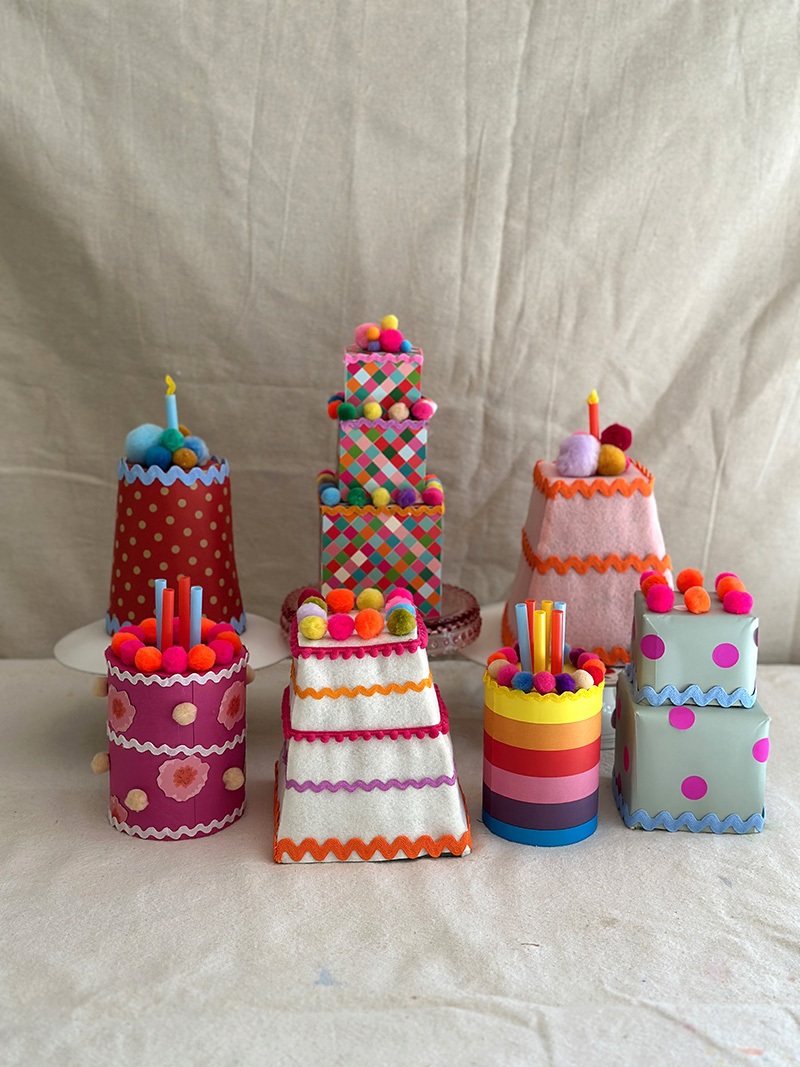 Cakes made from recycled materials, paper, felt, and pom-poms.