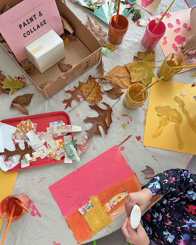 Child using glue to attach fabric scraps to her mixed-media collage.