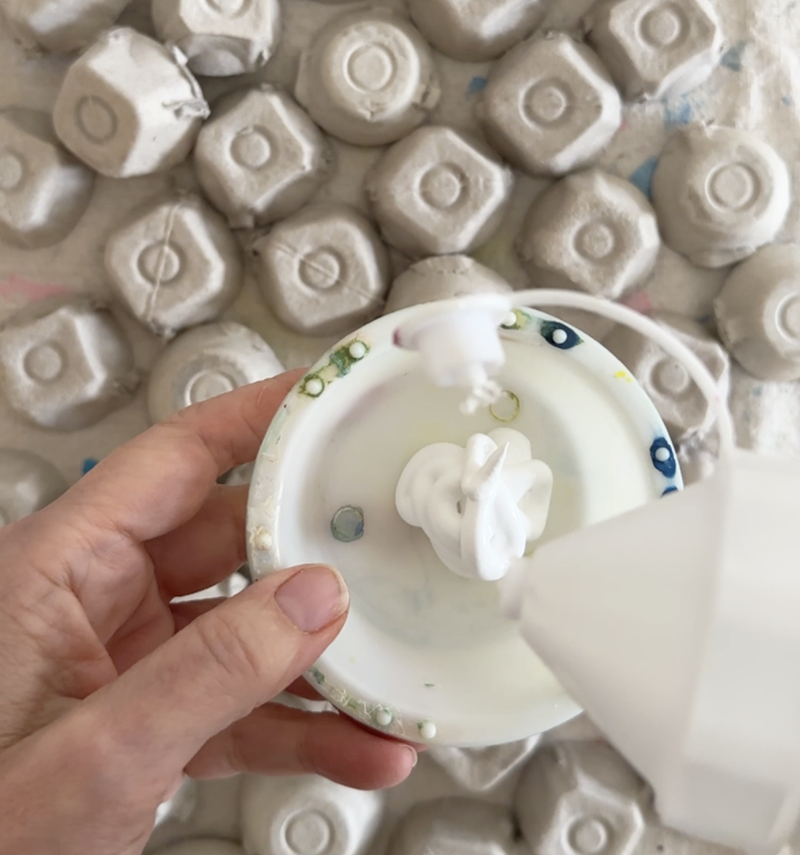 Paint the tops of the egg carton mushrooms white with acrylic paint.