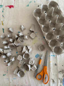 Cut the egg carton cups with an Xacto knife to make mushrooms.