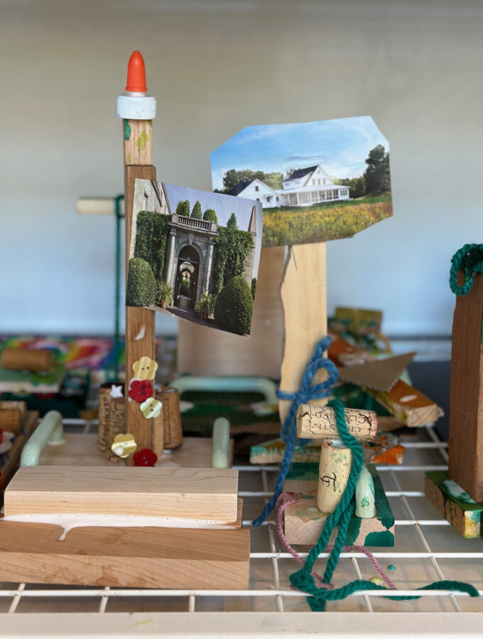 Children make sculptures with wood, glue, magazines, and other collage materials and dry them on a rack.