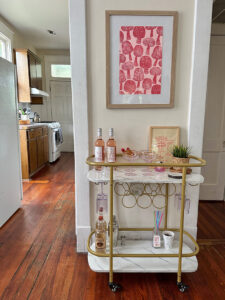 Printed mushrooms made with styrofoam hanging above a bar cart in an apartment.