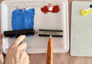 Rolling out primary colored printing inks on trays with a brayer.