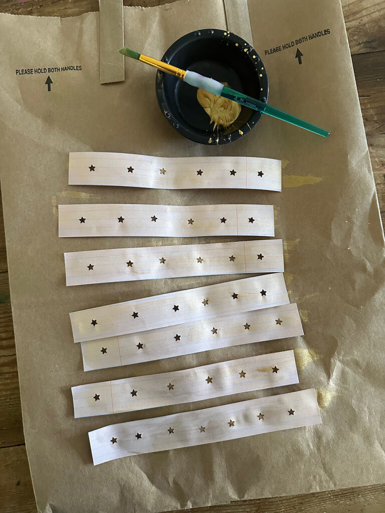 Make a paper chain using any paper that you have, a star hole punch, and some gold paint for a festive, shimmering room decor.